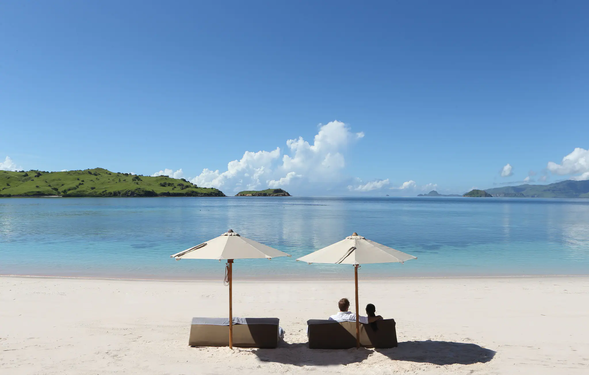 Alila Purnama Boutique Sailing Yacht | Private beach setup with parasols