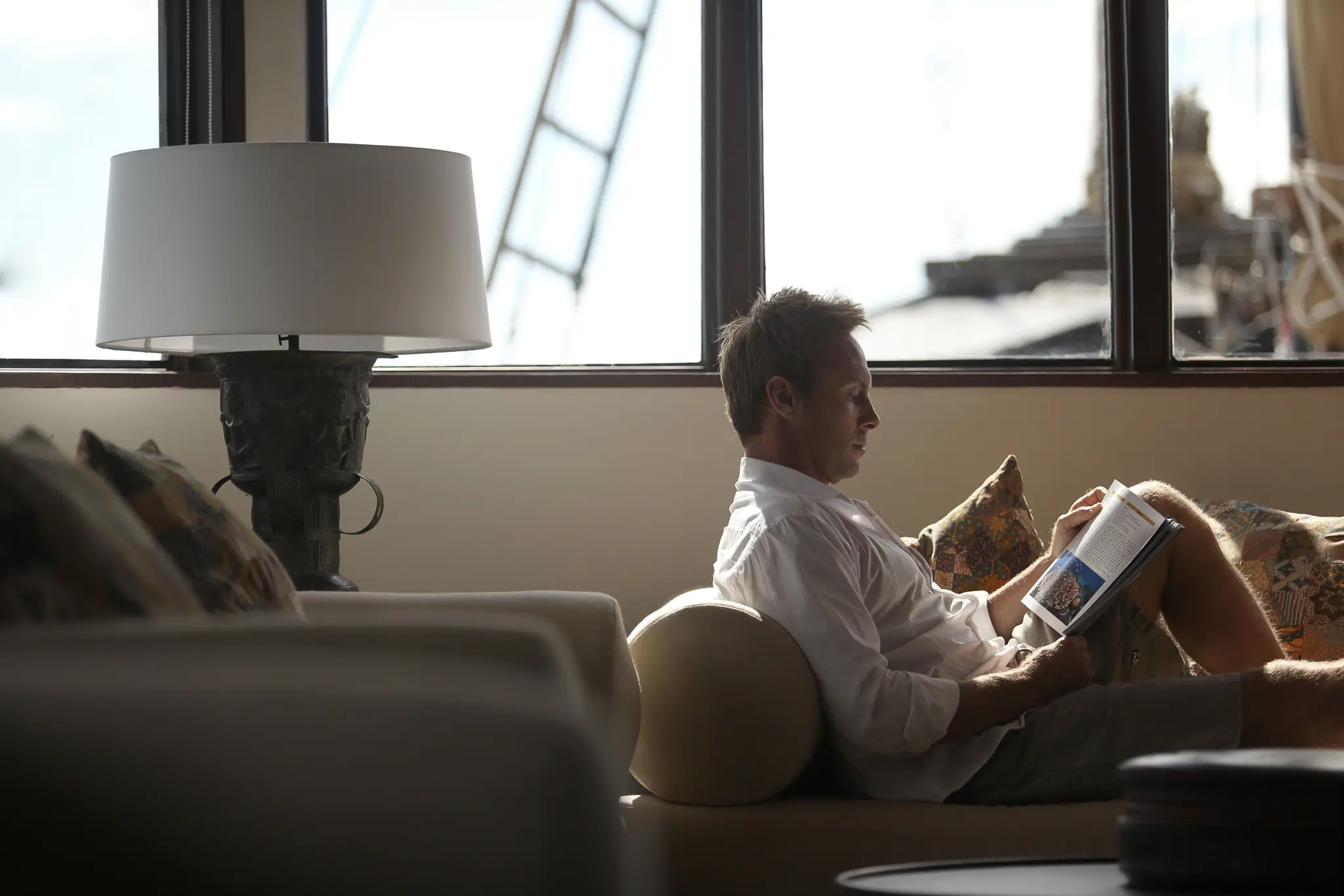 Alila Purnama Boutique Sailing Yacht | Guest relaxing in indoor lounge