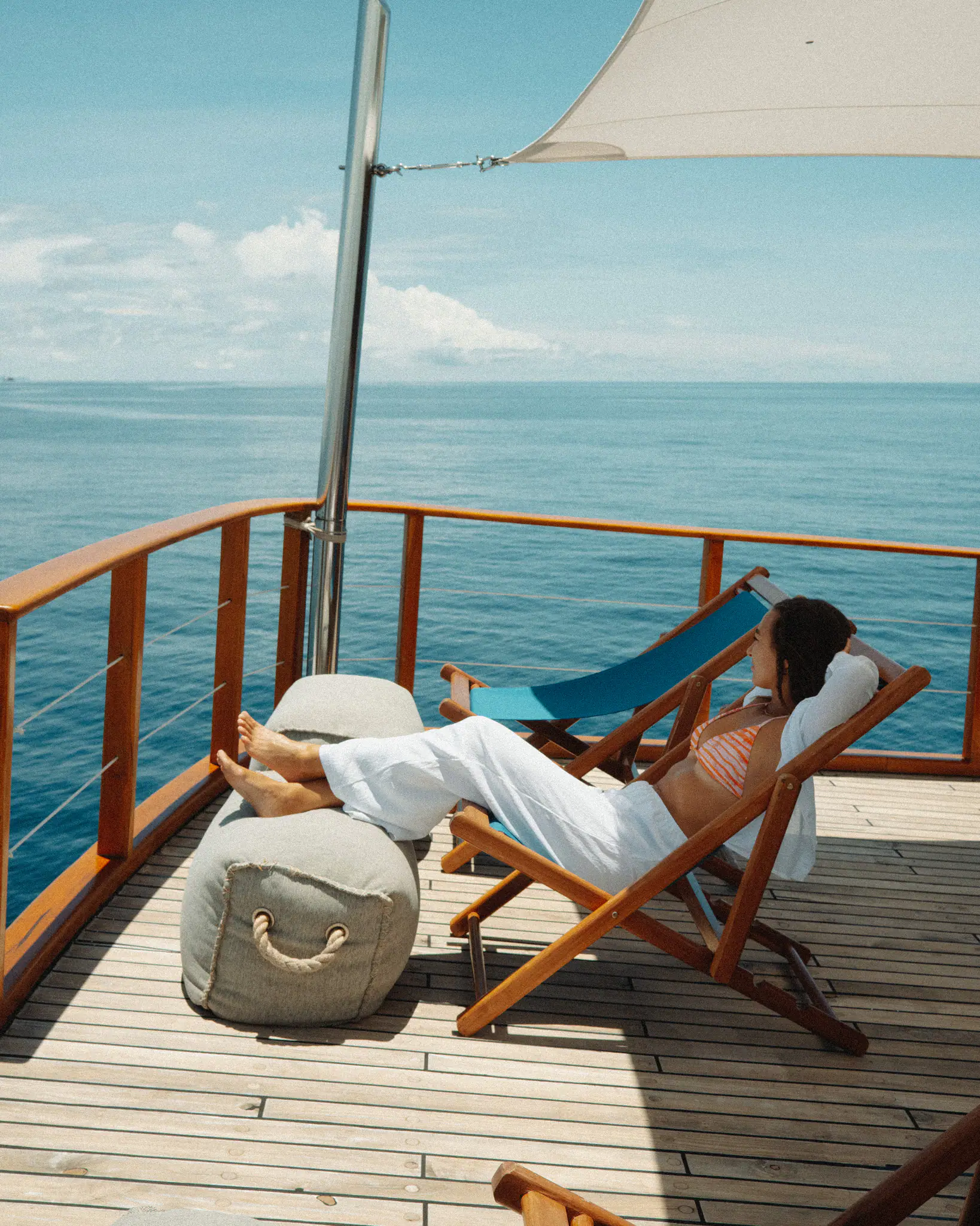 Rebel Adventure Yacht | Guest relaxing on deck lounger