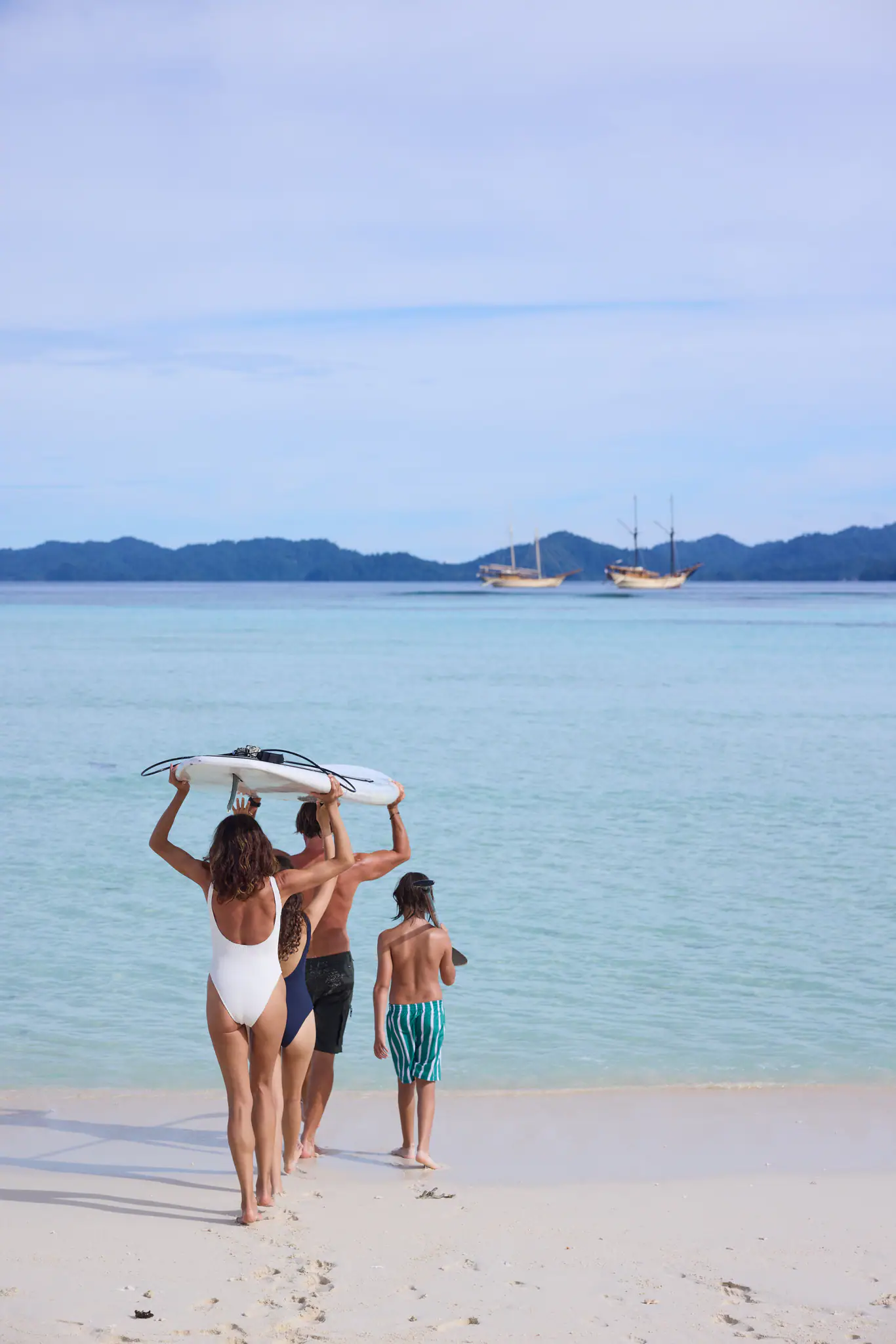 Silolona Heritage Sailing Yacht | Guests carrying paddleboards on beach
