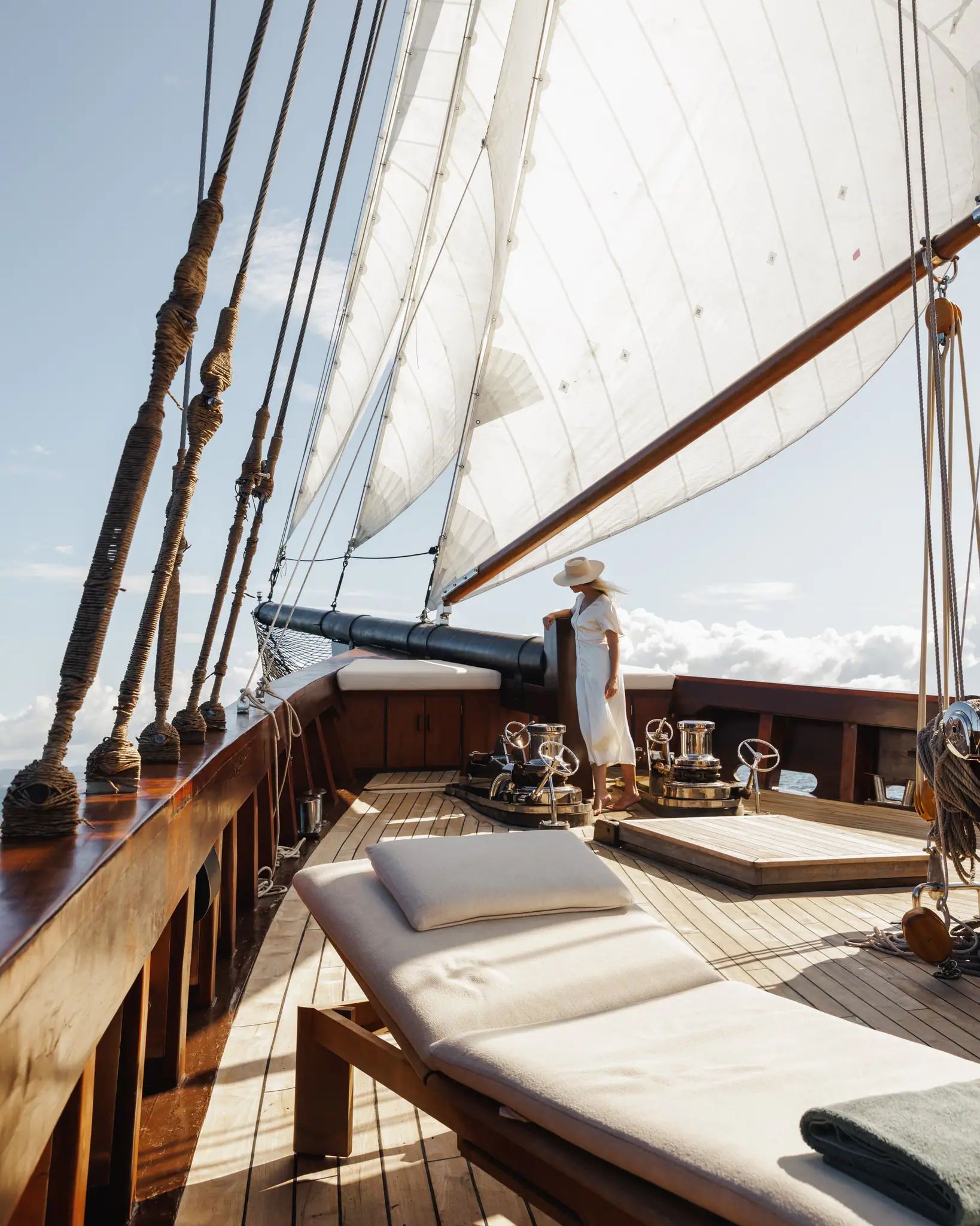 Vela Luxury Phinisi Yacht | Bow lounge beneath traditional sails